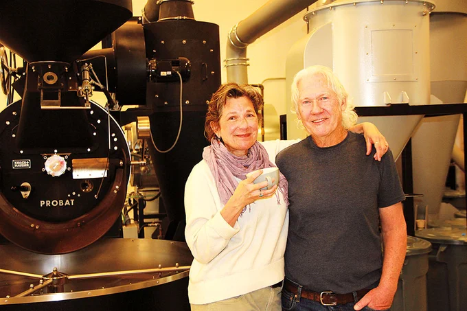 Meg and Dan Donohue pose by a coffee roaster.