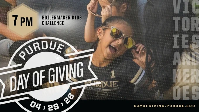Child wearing Purdue shirt and gold sunglasses smiling at outdoor PMU event.