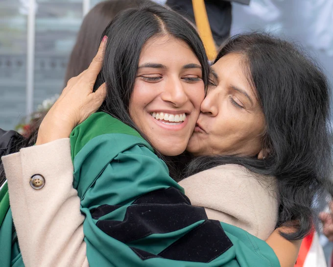 Ohiu University graduate embraces a family member in a hug.