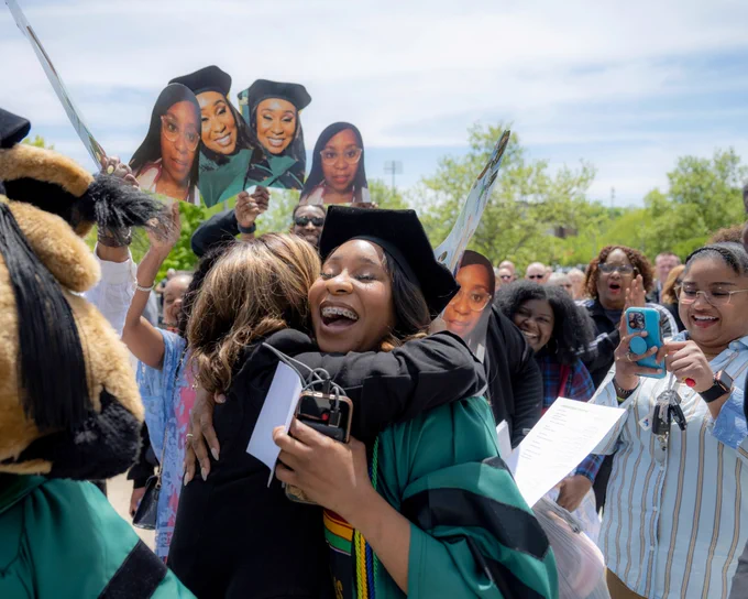 Ohiu University graduate embraces a family member in a hug.