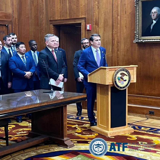Acting AG Todd Blanche speaking at a podium with ATF Deputy Director Robert Cekada. 