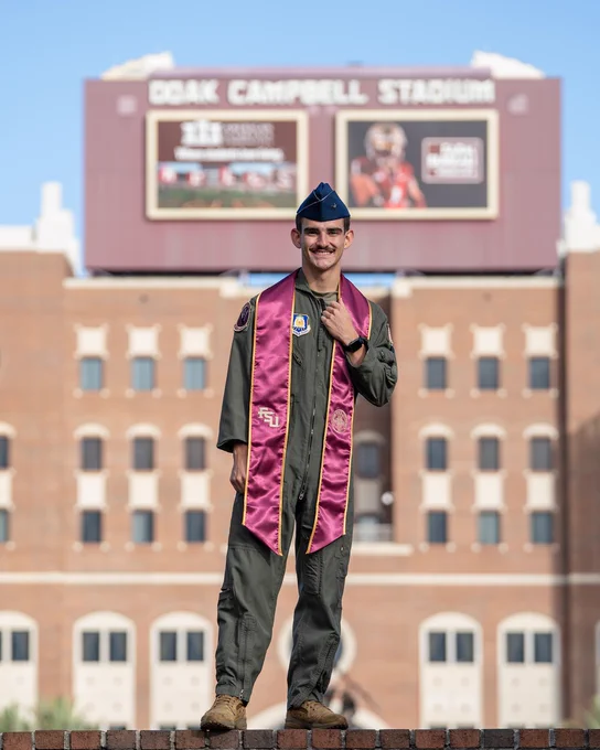 Graduation photo of Philip Quattrochi standing in front of the FSU football stadium.