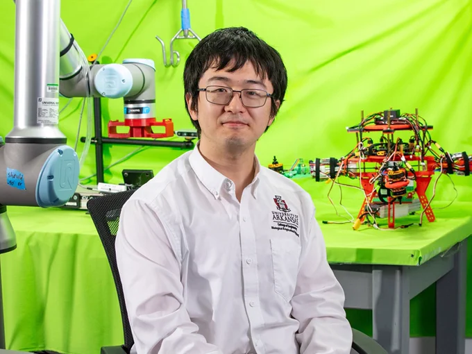 Dongyi Wang in his lab with robotics equipment.