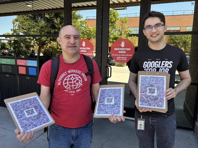 two AWU members pose outside a Google campus in Mountain View holding clipboards and flyers of a collage of photos of Googlers for Job Security supporters.