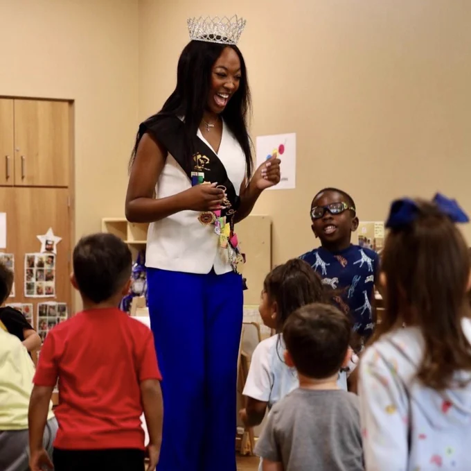 2026 San Antonio Queen of Soul, Kamarie Crawford, smiling at children in a Pre-K 4 SA classroom.

