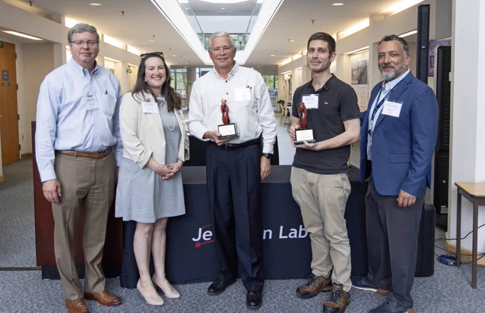 A group of people, several of which are holding glass trophies. 