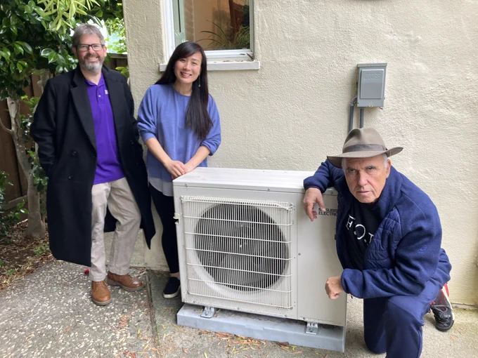 people in front of a heat pump