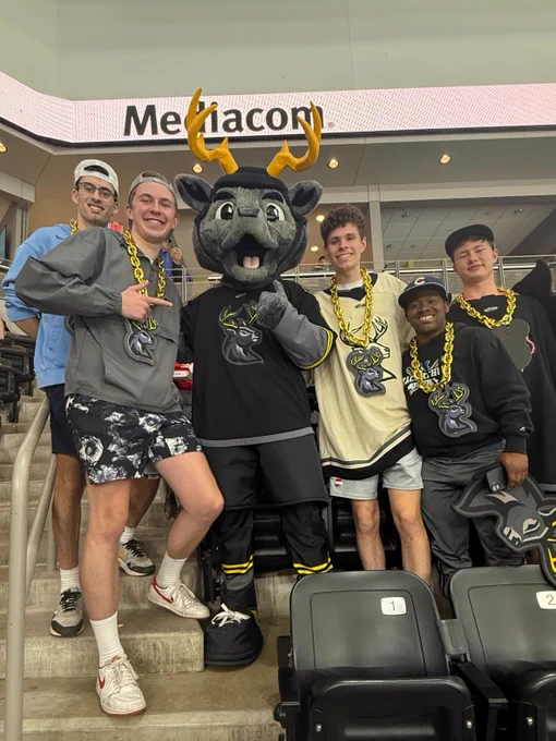 Five UI REACH students stand with the Iowa Heartlanders mascot.