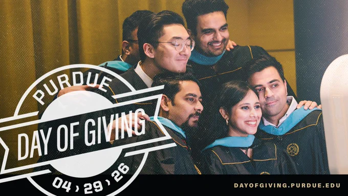 A group of people wearing graduation attire pose together, smiling, during a celebration event. The image includes a graphic overlay with the words "Purdue Day of Giving 04.29.26" and a website link "dayofgiving.purdue.edu".