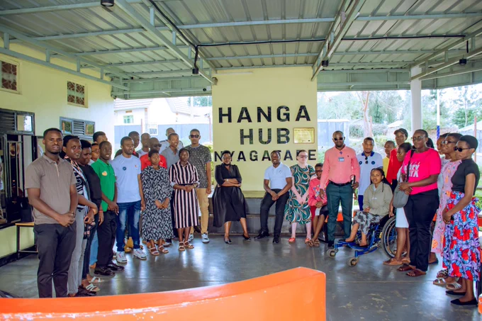 A group photo of people with HANGA HUB NYAGATARE Written on the wall