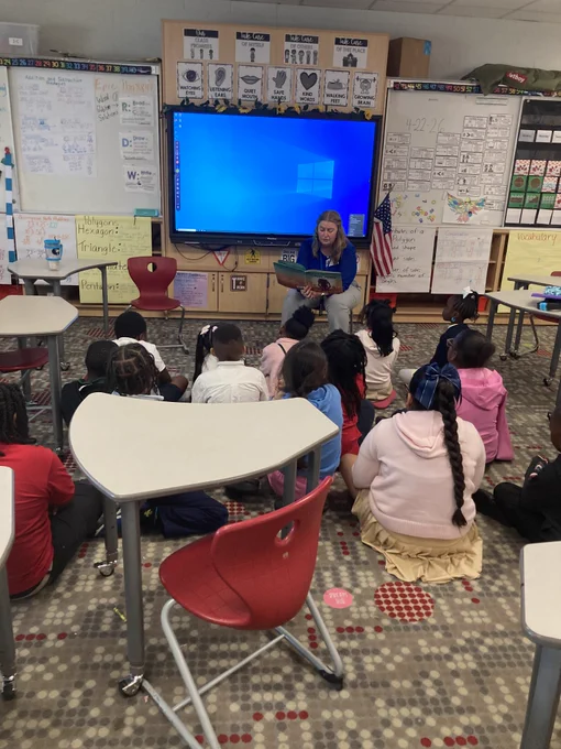 Employee reading to students