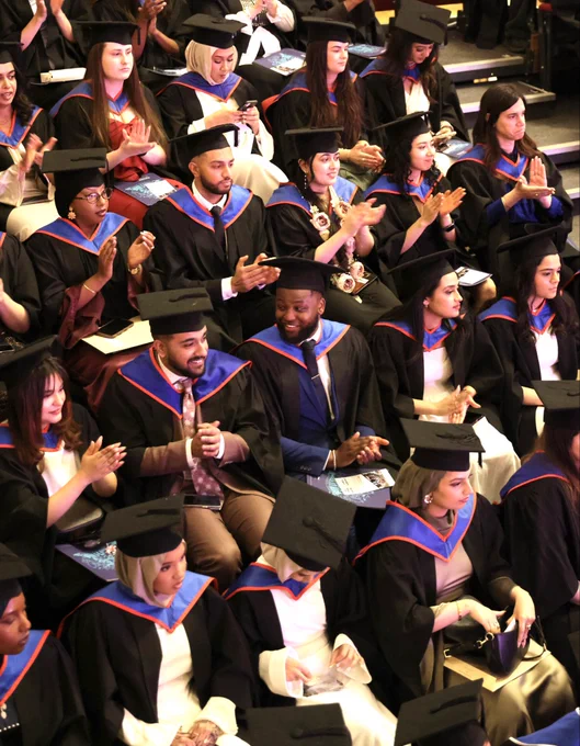 Graduates in the ceremony clapping