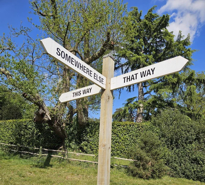 Wooden signpost with arms saying 'This way', 'That way' and 'Somewhere else'
