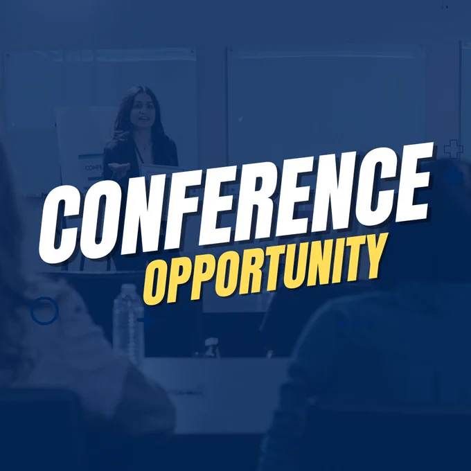 Speaker presenting at a professional conference with attendees listening in a modern meeting room.