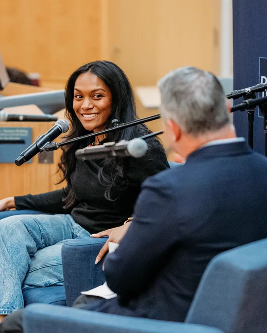 Dare to Disrupt guest Asia Grant with host Ryan Newman on stage during LIVE podcast recording.