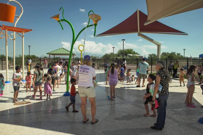 A photo of Barrio Nopal Splash pad with families enjoying the water.