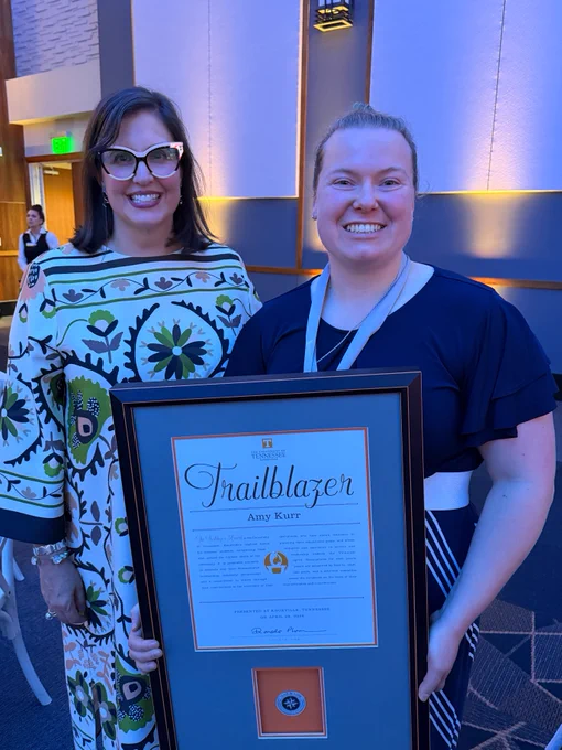 Amy Kurr, winner of the Trailblazer award, displaying her framed certificate, with Marieke Van Puymbroeck, the Dean of the Graduate School.