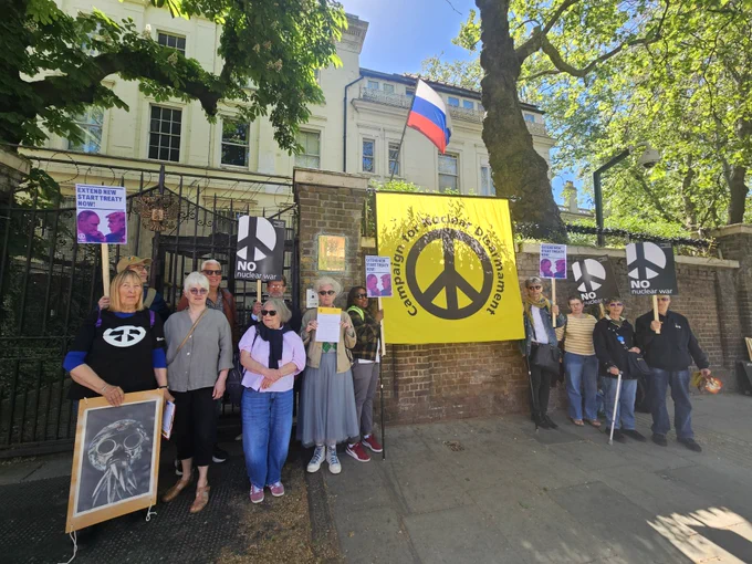 Protesters stand outside the Russian Embassy with CND banner and no nuclear war placards. 