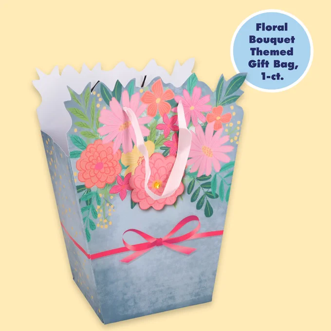 Decorative gift bag with a colorful floral bouquet design and a pink ribbon on a light blue background.