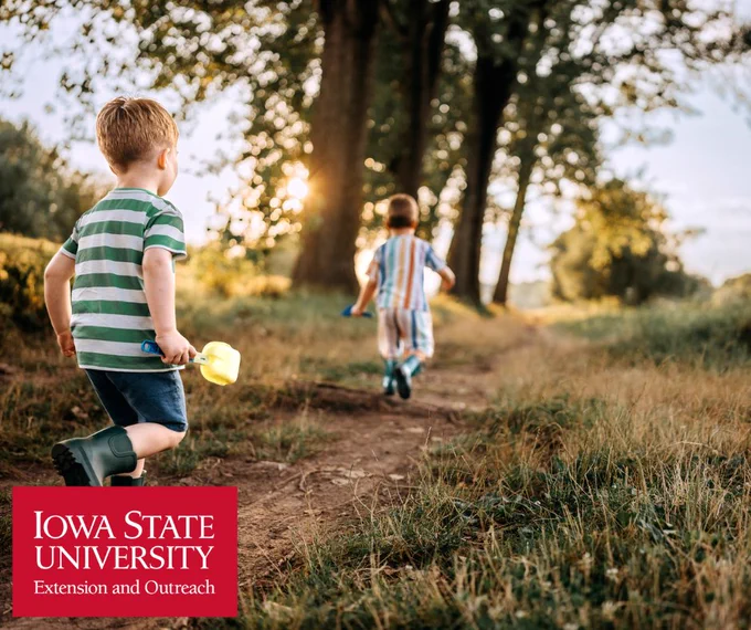children running on a trail in a wooded area on a sunny day