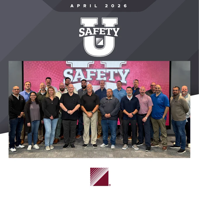 Group photo of 20 professionals standing in front of a large screen displaying 'Safety U' in April 2026.