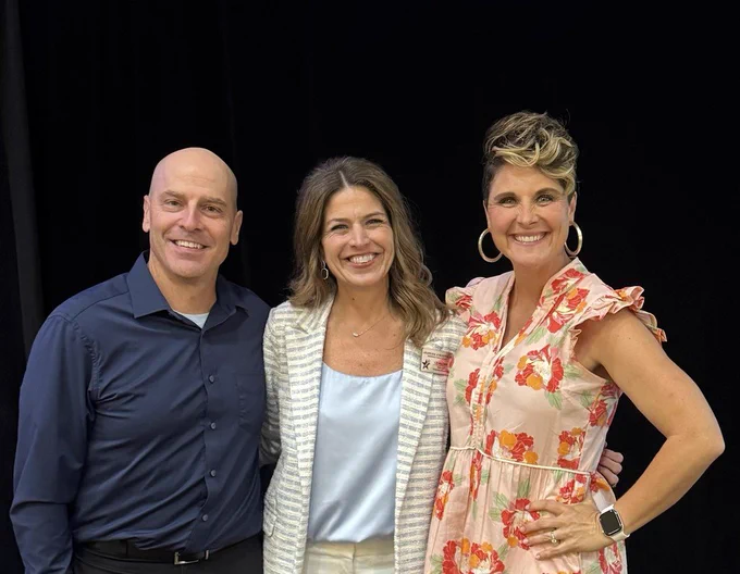 A group photo of three smiling educators standing together against a black background. On the left, a man in a navy blue button-down shirt (Coach Sode); in the center, a woman in a light blue top and striped blazer (Principal Hilcher); and on the right, a woman in a pink floral dress with large hoop earrings (Coach McDougal).