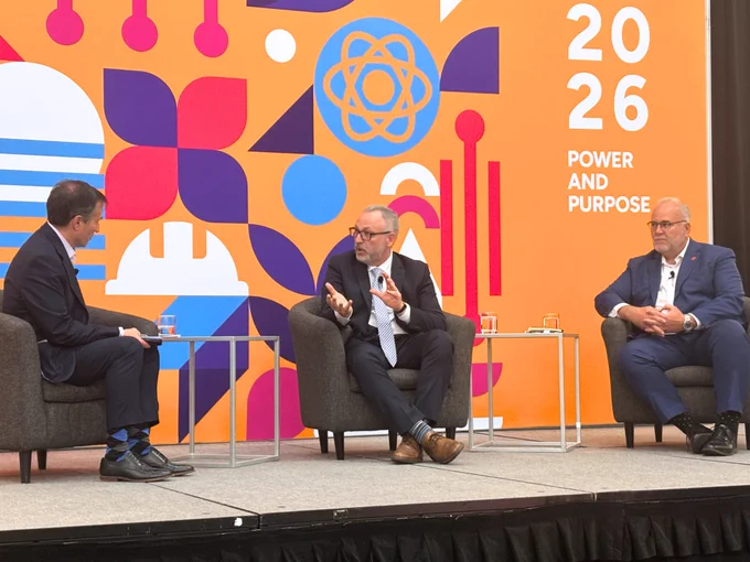 Ontario Tech President and Vice-Chancellor, Dr. Steven Murphy, participates in a panel discussion at the CNA 2026 Conference. There is a bright and colourful backdrop on the stage behind him that says "2026 Power and Purpose". Two other panelists are seated on either side of him.
