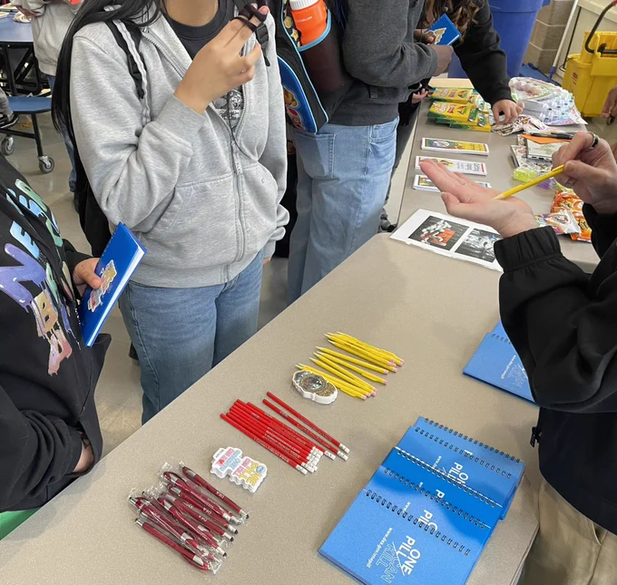 School kids at a table with DEA material, hearing about the dangers of fentanyl