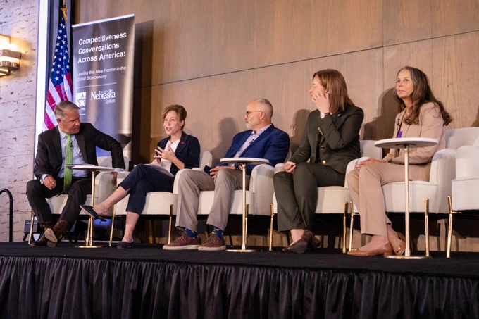 Group of panelists sitting on stage at the competitiveness conversation