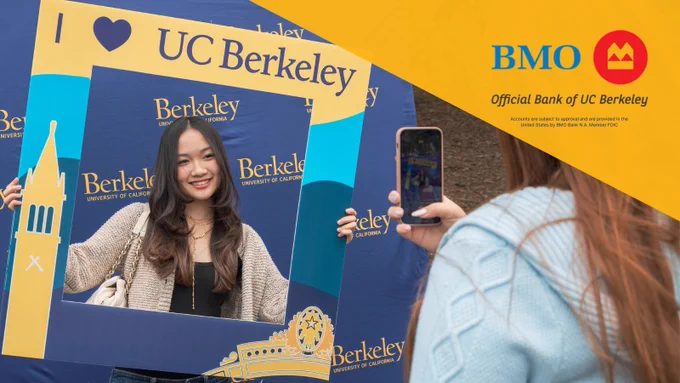 An image of a newly admitted UC Berkeley student taking a photo with a "I <3 UC Berkeley cardboard frame" with the top right corner covered in a yellow graphic that shows the logo of BMO, the official bank of UC Berkeley.