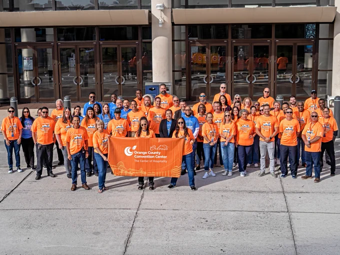A large group of Orange County Convention Center employees who have signed up to participate in the AdventHealth Corporate 5K. The group has gathered for a group photo prior to participating in the race. 