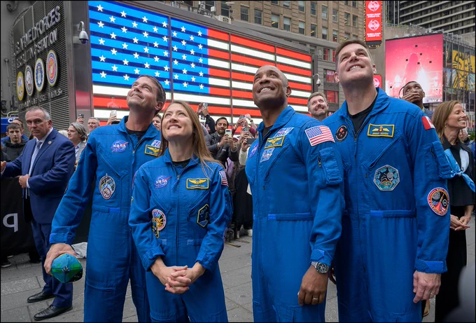 NASA’s Artemis II crewmembers: NASA astronauts Reid Wiseman, commander; left,   Christina Koch, mission specialist; Victor Glover, pilot; and CSA (Canadian Space Agency) astronaut Jeremy Hansen, mission specialist, right, watch a replay of them ringing the closing bell of the Nasdaq market session, Thursday, April 30, 2026, in Times Square, New York. NASA’s Artemis II mission took Wiseman, Glover, Koch, and Hansen on a nearly 10-day journey around the Moon and back to Earth earlier in April 2026. Photo Credit: (NASA/Bill Ingalls)