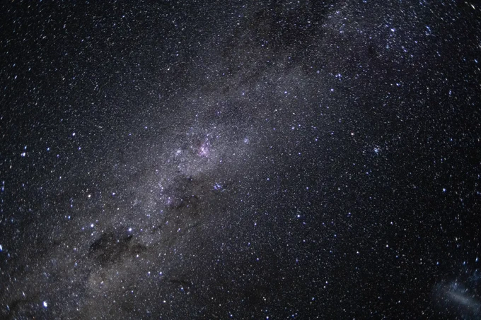 Vast night sky filled with countless stars and a visible stretch of the Milky Way galaxy.