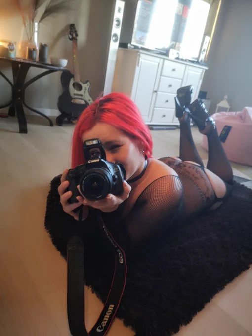 Sexy Norwegian woman in lingerie taking a photo using a professional DSLR camera