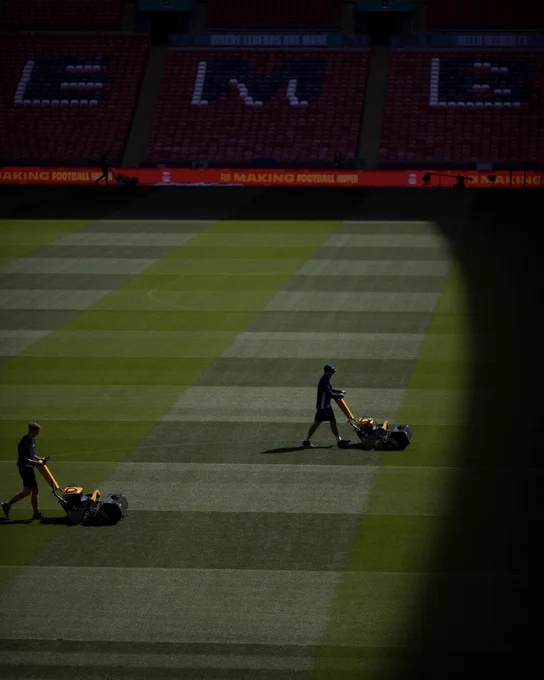 A picture of the Wembley Stadium grounds team cutting the grass.