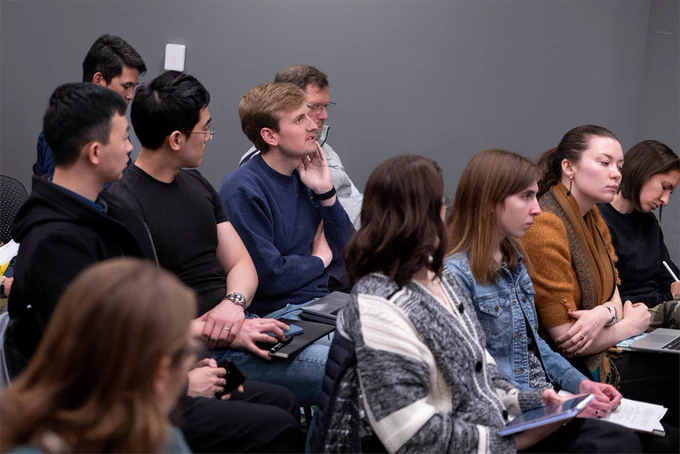 An audience member asks a question as others look on.