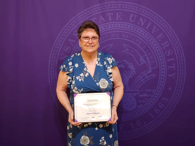 Mary Winnie holding her award plaque