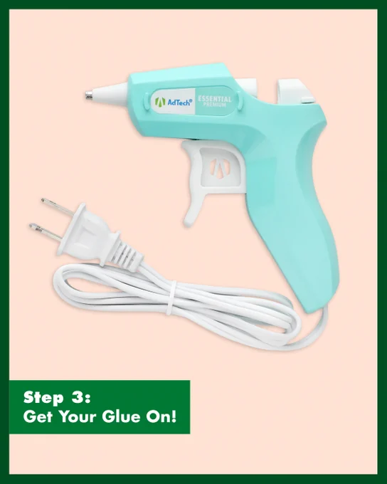 Light blue electric glue gun with a white trigger and attached power cord on a pale pink background.