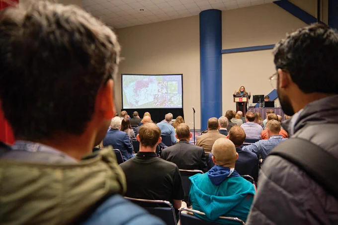 Attendees standing in the back of a session room filled with attendees at the 106th Annual Meeting. Photo credit: Dee Zunker Photography.
