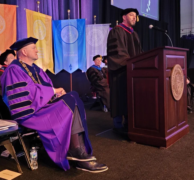 Anastasios Kamoutsas speaks at a podium during FSW's commencement ceremony.