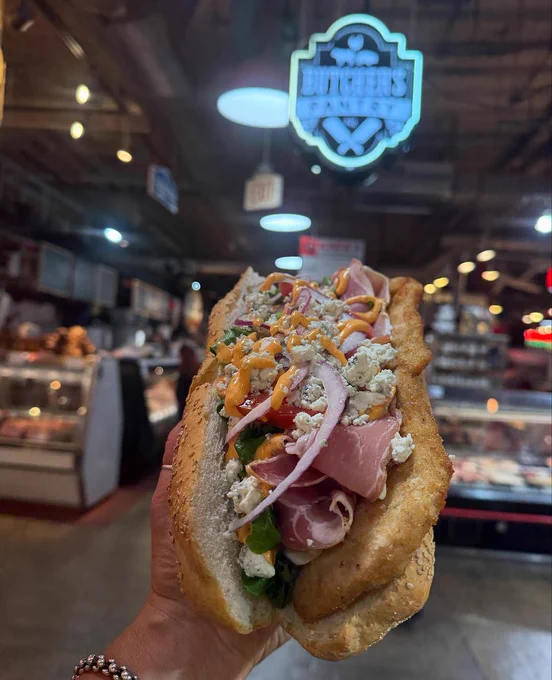 A deliciously over-stuffed hoagie being proudly displayed in front of Butcher's Pantry