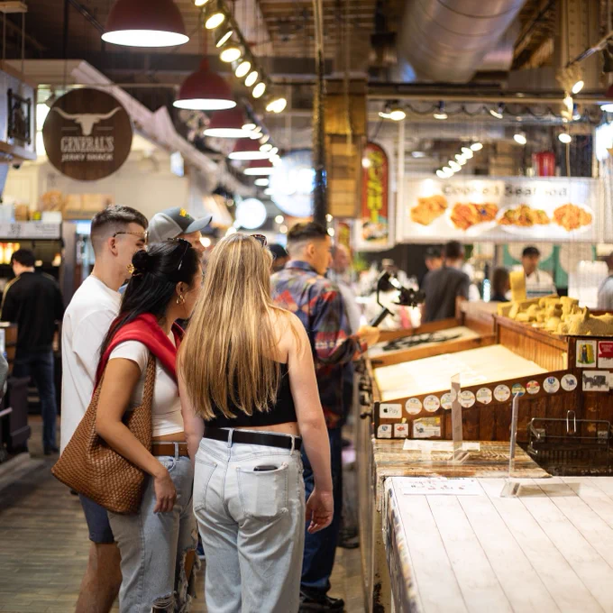 Market shoppers taking in their many options along a bustling concourse of vendors