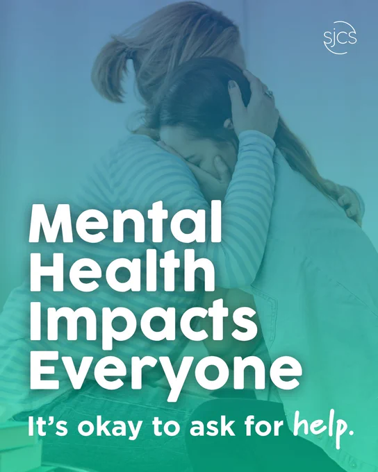 Two people sharing a warm, comforting embrace. A blue-to-green gradient overlays the image with bold white text reading "Mental Health Impacts Everyone. It's okay to ask for help." The SJCS logo appears in the upper right corner.