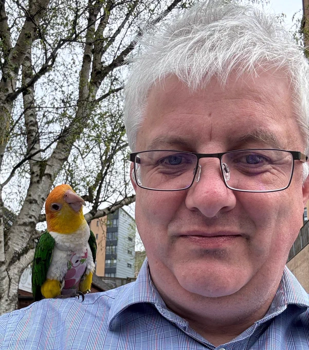 James Adams with a parrot on his shoulder