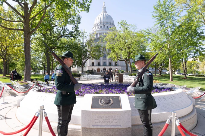 Two law enforcement officers in front of the Law Enforcement Memorial at the Wisconsin State Capitol