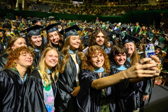 Ohio University grads pose for a group selfie in the Convocation Center.