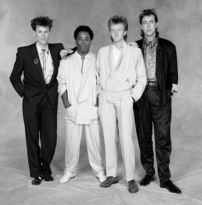 Black-and-white promo shot of Big Country in their mid-’80s rise — sharp stance, locked in, and carrying that unmistakable Celtic-rock drive that set them apart.