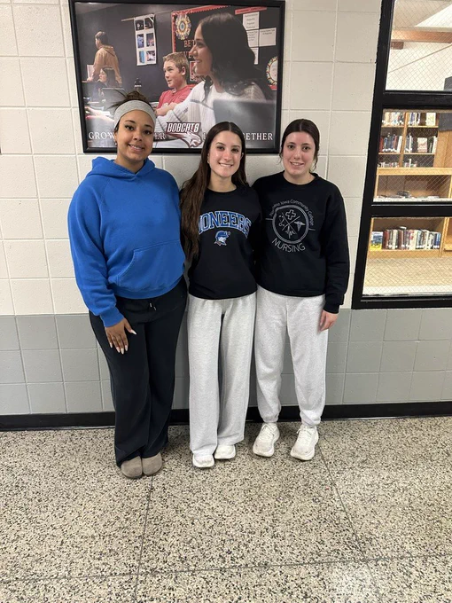 Three girls smiling at the camera.