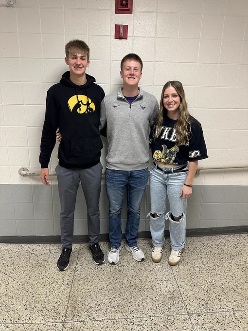 Three students smiling at the camera.