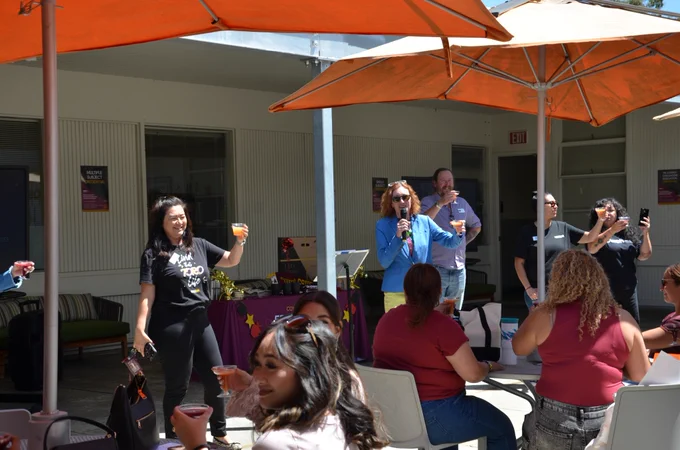 College of Education Dean, Dr. Jessica Pandya, and others raising their drinks to toast for the graduating Liberal Studies seniors